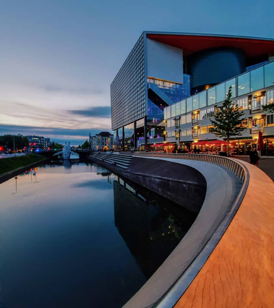 Gebogen lijnen van TivoliVredenburg in Utrecht bij avond, smartphonefoto