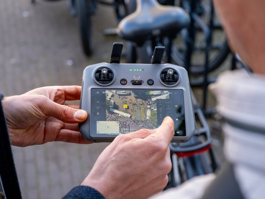 De controller in de hand, met het beeld van de drone