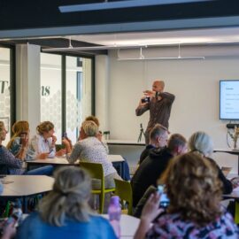 Maarten van Apeldoorn geeft de stoomcursus smartphone-fotografie aan een groep in een zaal