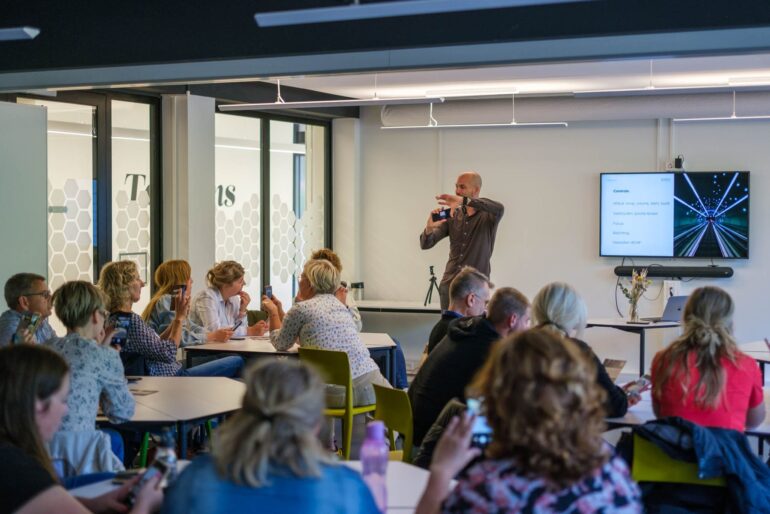 Maarten van Apeldoorn geeft de stoomcursus smartphone-fotografie aan een groep in een zaal